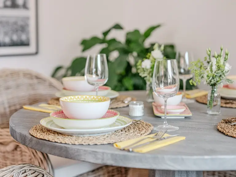 Elegant table setting with dinnerware and wine glasses at PEARL WHITE