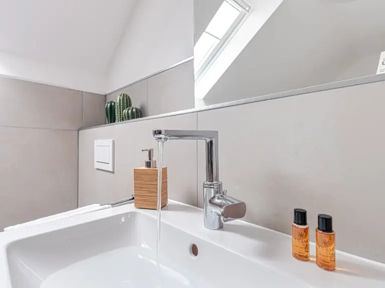 Modern bathroom sink with toiletries at PEARL SILVER