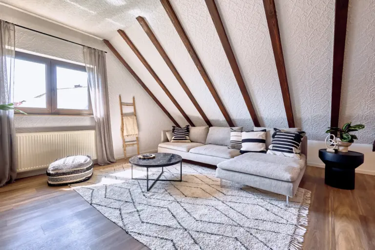 Bright living room with sectional sofa and exposed wooden beams at RUBY NOIR