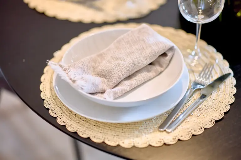 Elegant table setting with plates, napkin and wine glass at RUBY NOIR