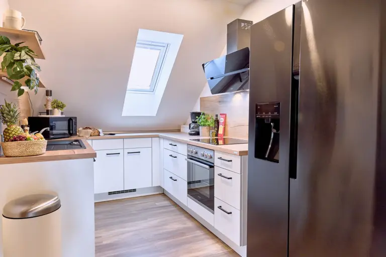 Modern kitchen with side-by-side fridge at RUBY NOIR