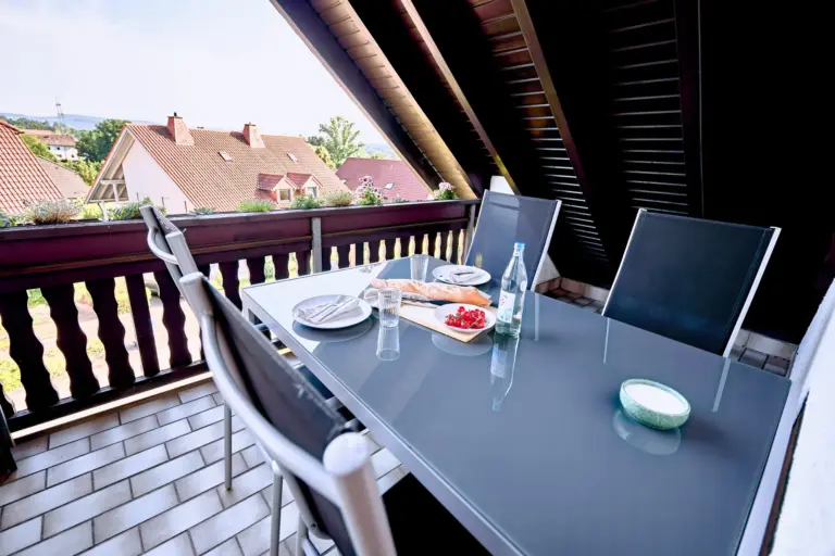 Furnished private balcony with outdoor dining table at RUBY NOIR