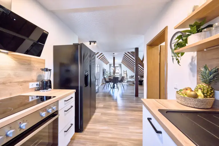 Kitchen with side-by-side fridge and view into the living area at RUBY NOIR