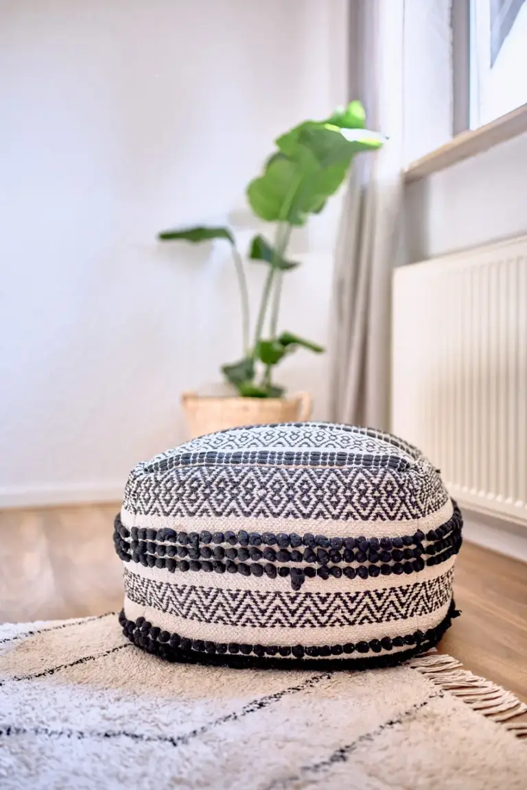 Decorative pouf and rug in the living room at RUBY NOIR