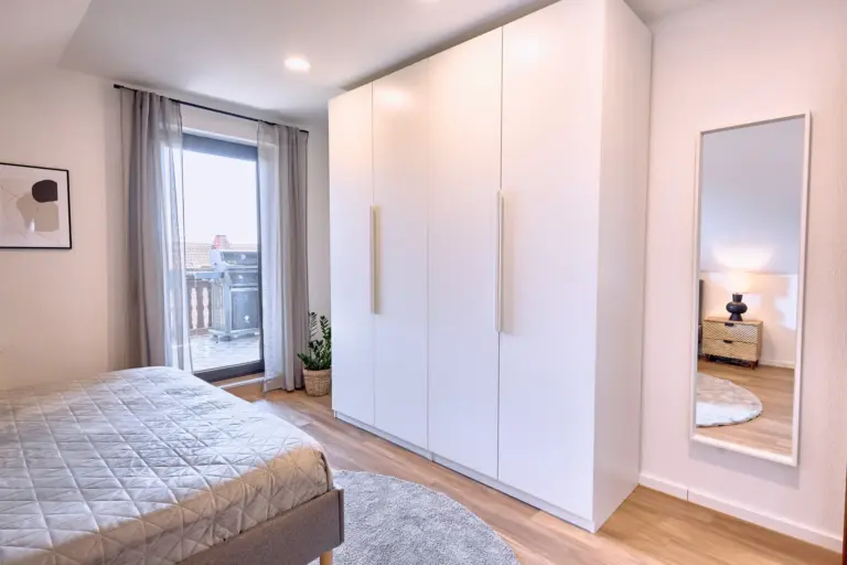 Large wardrobe and full-length mirror in the master bedroom at RUBY NOIR