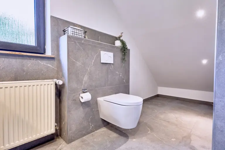 Modern bathroom with wall-mounted toilet at RUBY NOIR