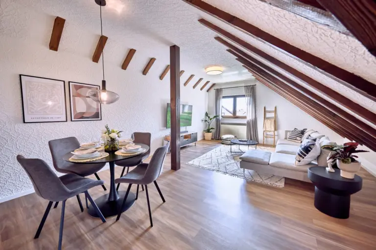 Spacious open-plan living and dining area with exposed wooden beams at RUBY NOIR