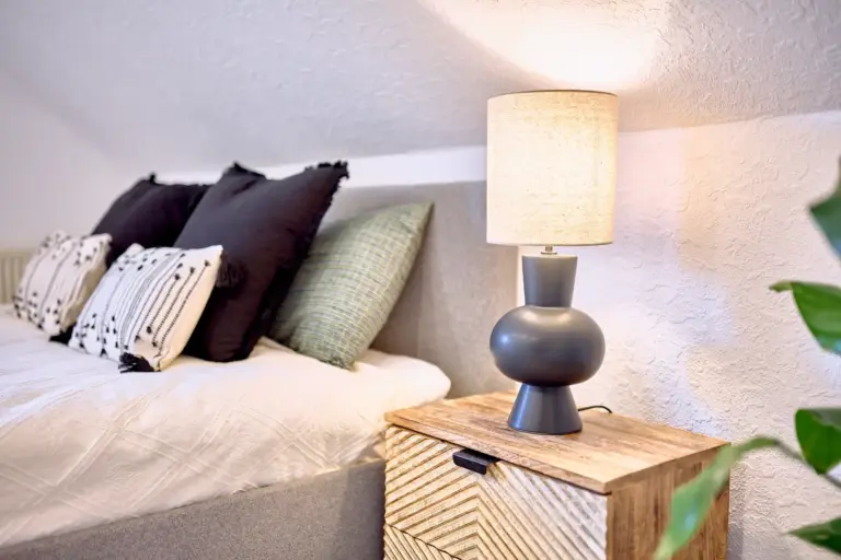 Bedside lamp and queen-size bed at RUBY NOIR