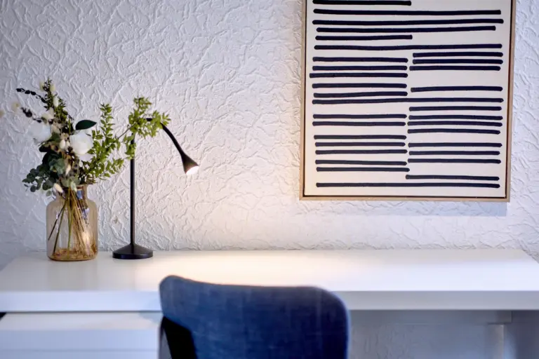 Decorative flowers, lamp and wall art in the workspace area at RUBY NOIR