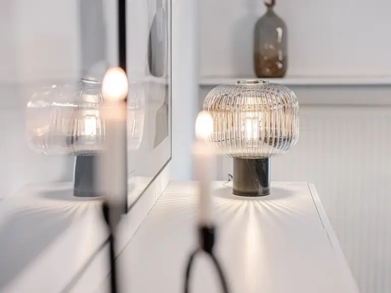 Decorative lamp and candle detail in the RUBY RED living room