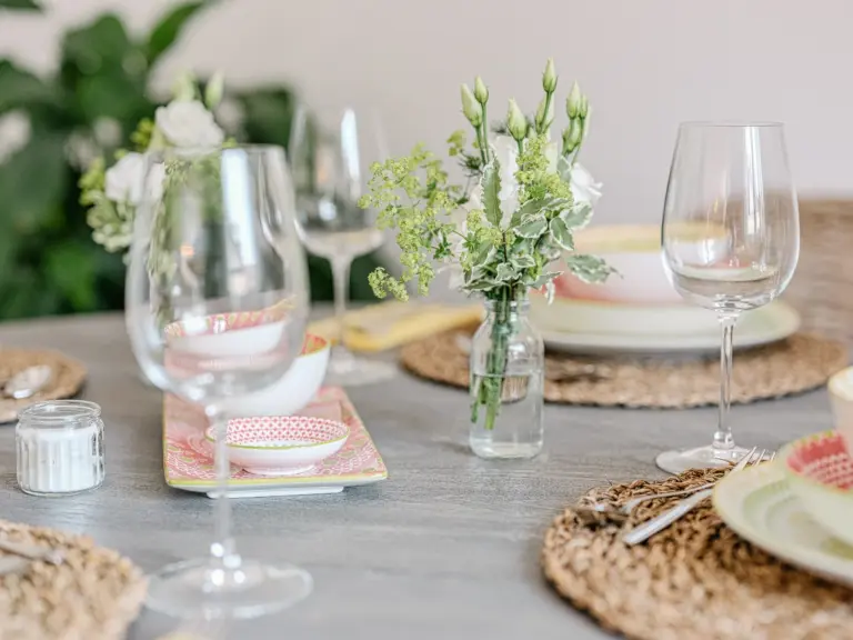 Dining table with flowers, dinnerware and wine glasses at PEARL WHITE