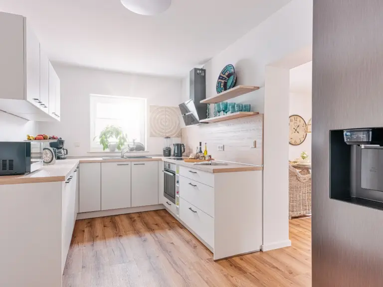 Fully equipped kitchen with side-by-side fridge at PEARL WHITE