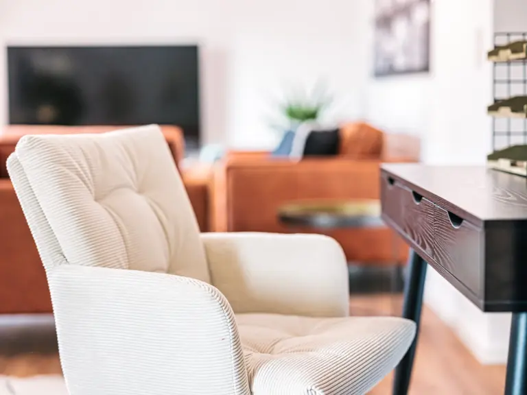 Comfortable desk chair with living room in the background at PEARL WHITE